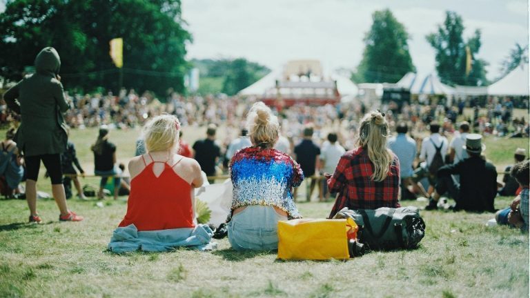 Three young women enjoying a lively atmosphere at a music festival, filled with excitement and energy.