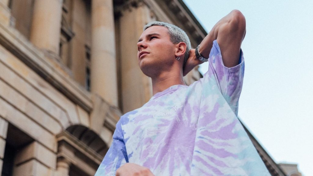 A man in a tie-dye shirt, a vibrant and artistic clothing option.
